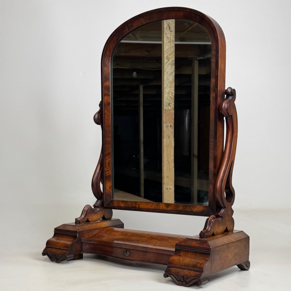 An antique Victorian dark mahogany tabletop dressing mirror featuring an arched frame supported by carved scroll uprights on a plinth base. View II