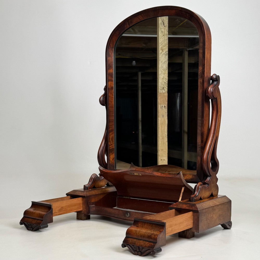 An antique Victorian dark mahogany tabletop dressing mirror featuring an arched frame supported by carved scroll uprights on a plinth base. View III