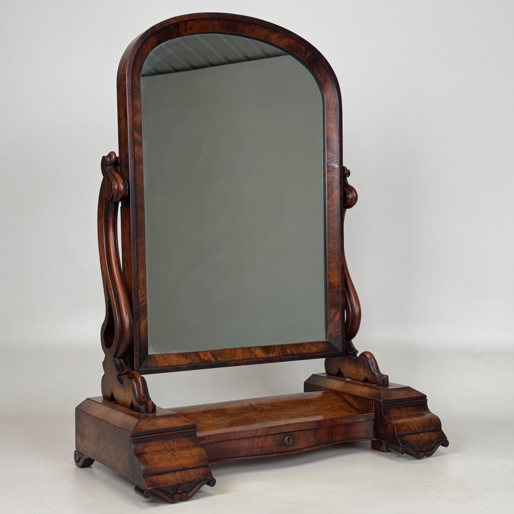 An antique Victorian dark mahogany tabletop dressing mirror featuring an arched frame supported by carved scroll uprights on a plinth base. View XI
