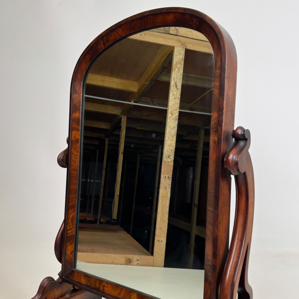 An antique Victorian dark mahogany tabletop dressing mirror featuring an arched frame supported by carved scroll uprights on a plinth base. View XIII