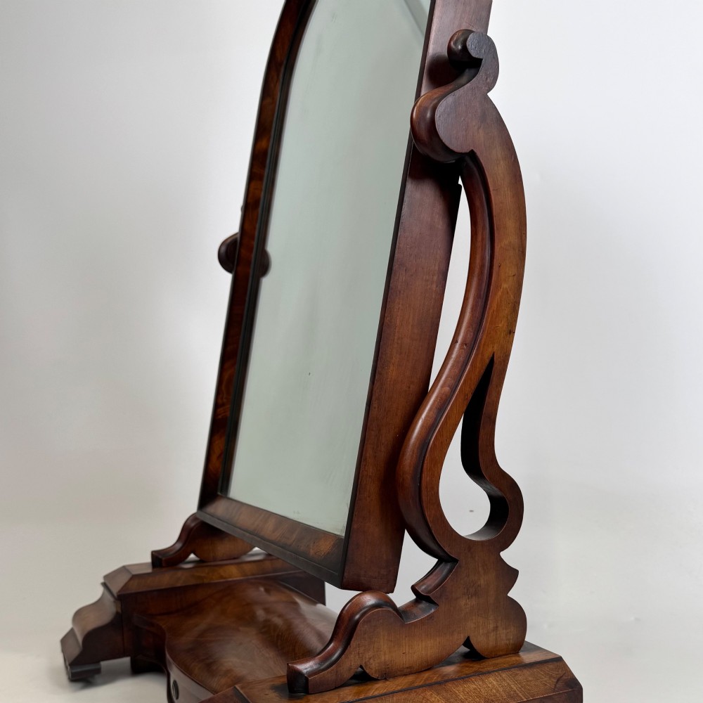 An antique Victorian dark mahogany tabletop dressing mirror featuring an arched frame supported by carved scroll uprights on a plinth base. View XIV
