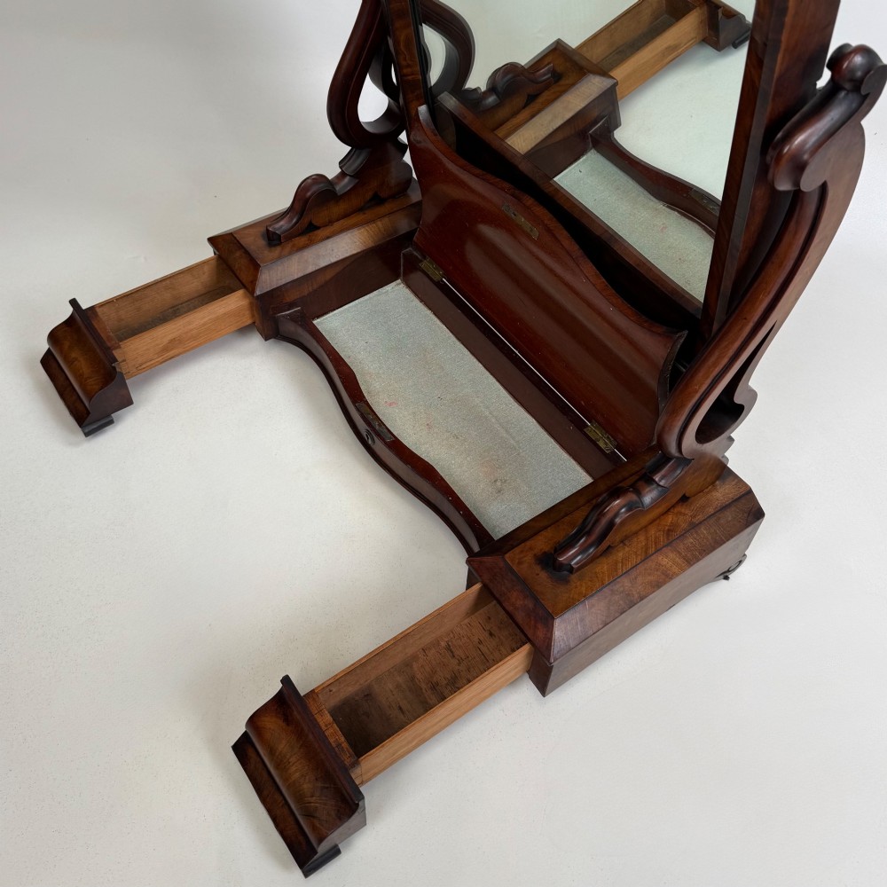An antique Victorian dark mahogany tabletop dressing mirror featuring an arched frame supported by carved scroll uprights on a plinth base. View XV