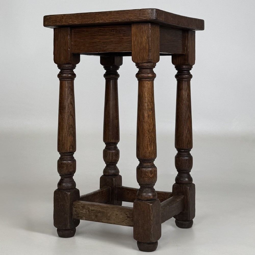 A set of three dark oak Edwardian stools featuring rectangular wooden tops, turned legs, and lower perimeter stretchers. View III