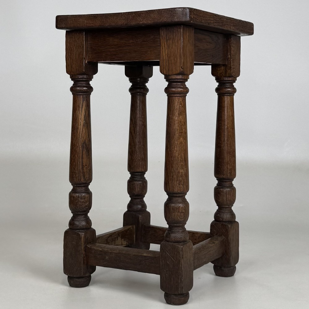 A set of three dark oak Edwardian stools featuring rectangular wooden tops, turned legs, and lower perimeter stretchers. View V