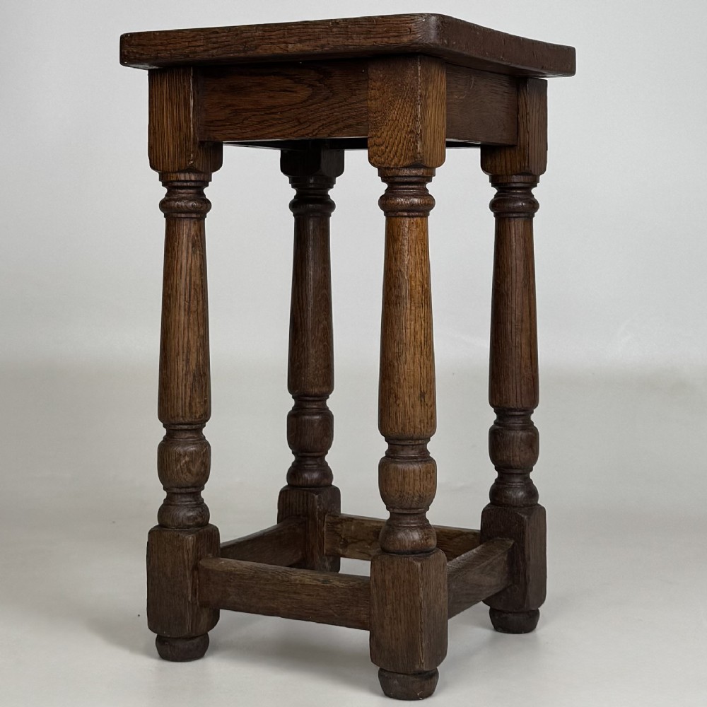 A set of three dark oak Edwardian stools featuring rectangular wooden tops, turned legs, and lower perimeter stretchers. View VII