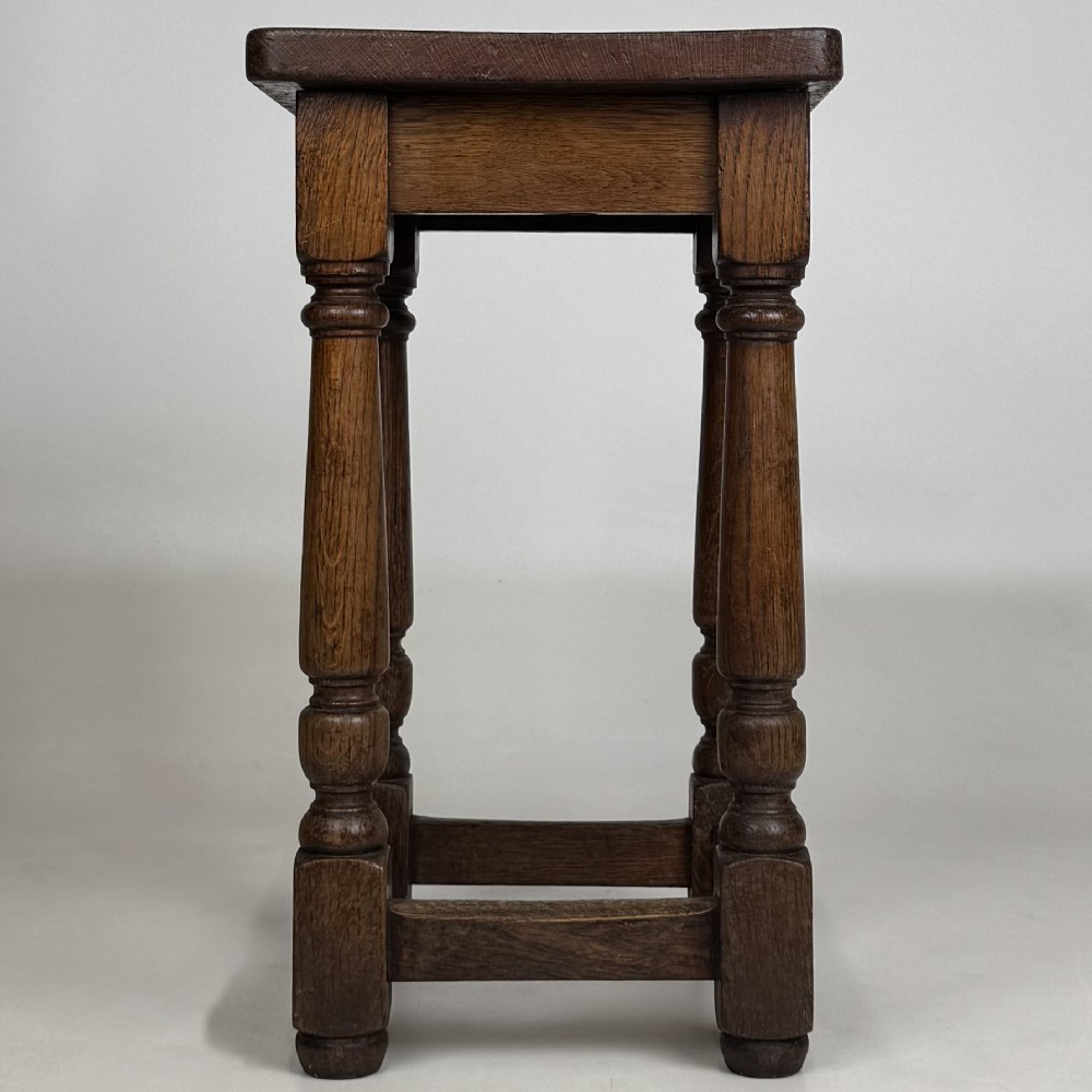A set of three dark oak Edwardian stools featuring rectangular wooden tops, turned legs, and lower perimeter stretchers. View VIII