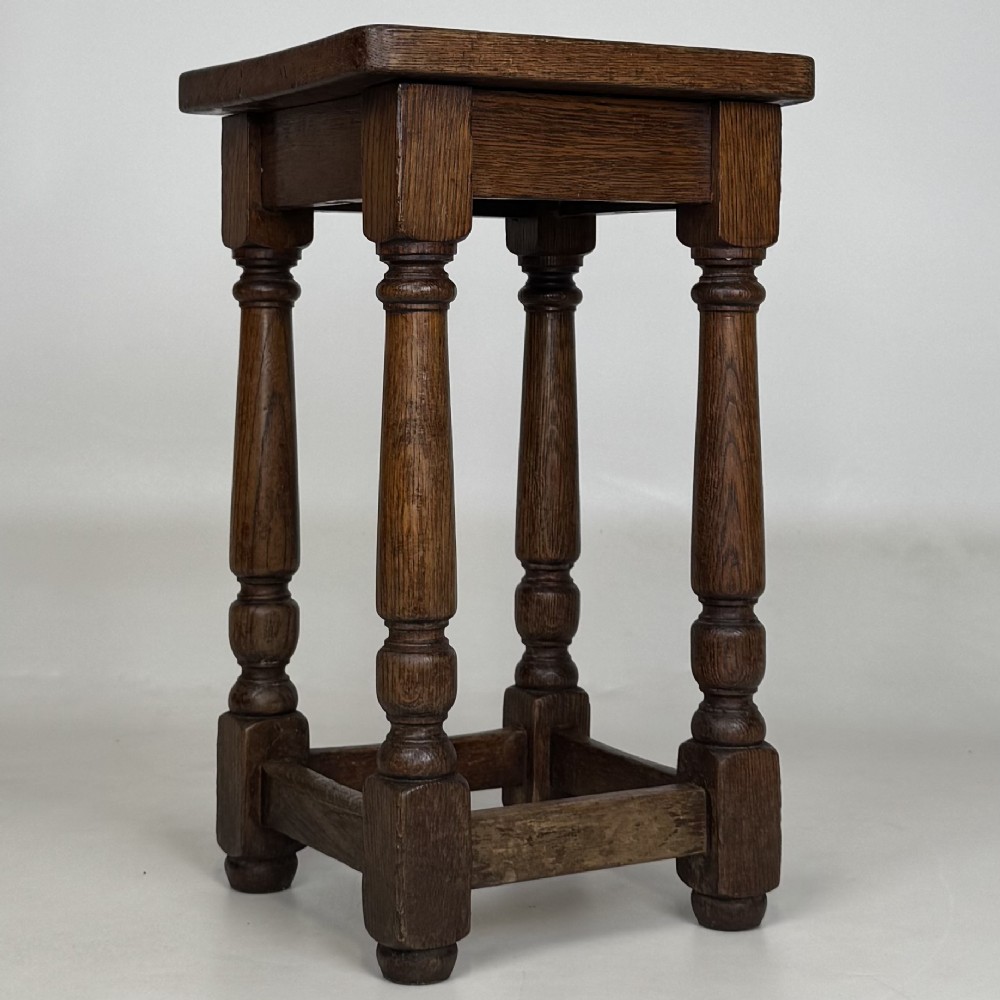 A set of three dark oak Edwardian stools featuring rectangular wooden tops, turned legs, and lower perimeter stretchers. View IX