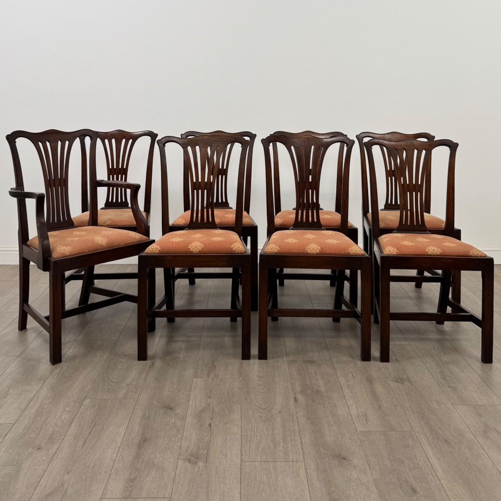 A set of eight 19th-century Georgian style mahogany dining chairs featuring carved pierced splat backs and patterned terracotta upholstery.