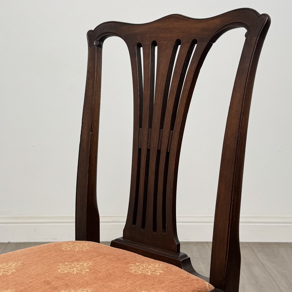 A set of eight 19th-century Georgian style mahogany dining chairs featuring carved pierced splat backs and patterned terracotta upholstery. View V