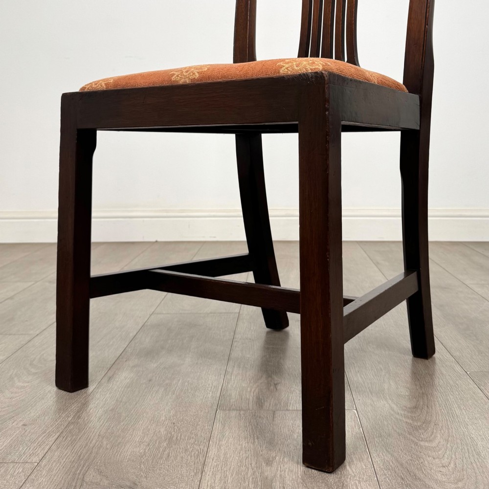 A set of eight 19th-century Georgian style mahogany dining chairs featuring carved pierced splat backs and patterned terracotta upholstery. View VI