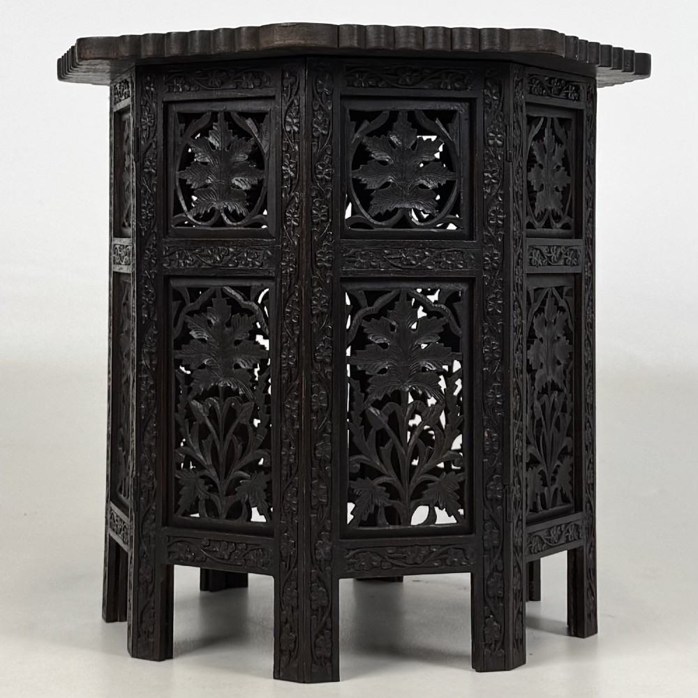 A dark brown octagonal wooden side table featuring intricate hand-carved foliate openwork panels across every side. View II