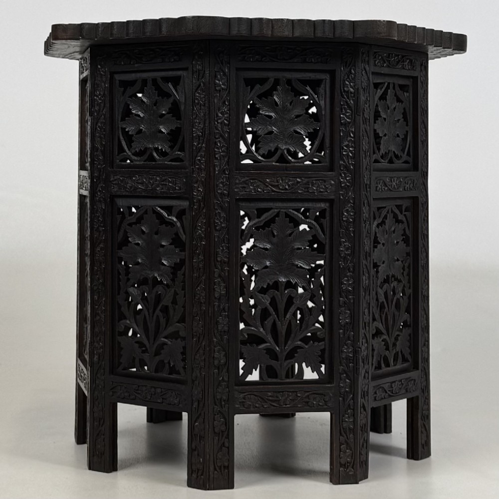 A dark brown octagonal wooden side table featuring intricate hand-carved foliate openwork panels across every side. View IV