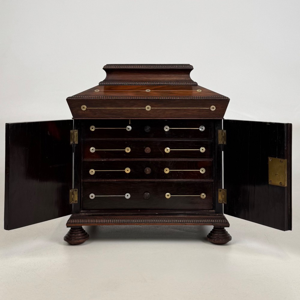 An antique dark rosewood box featuring mother-of-pearl floral inlays, twin front doors, a sarcophagus top, and turned feet. View II