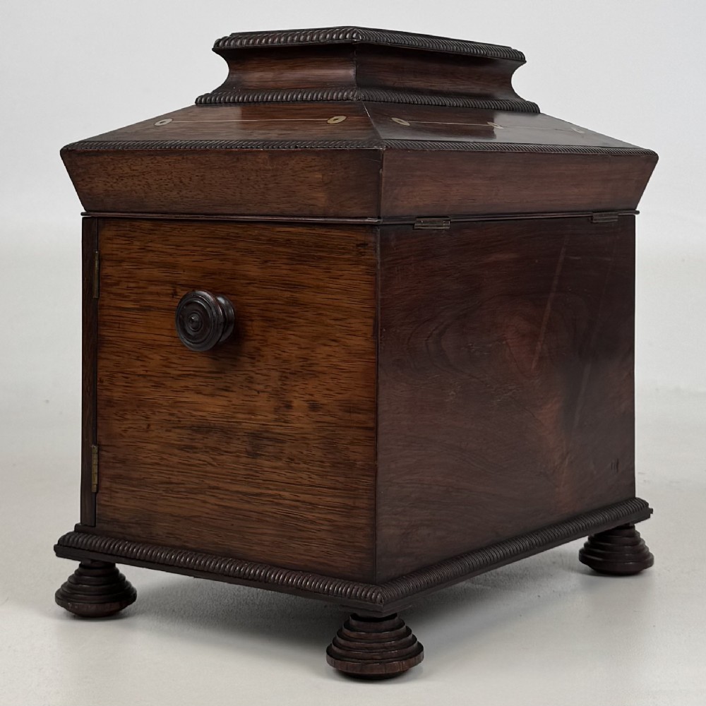 An antique dark rosewood box featuring mother-of-pearl floral inlays, twin front doors, a sarcophagus top, and turned feet. View V