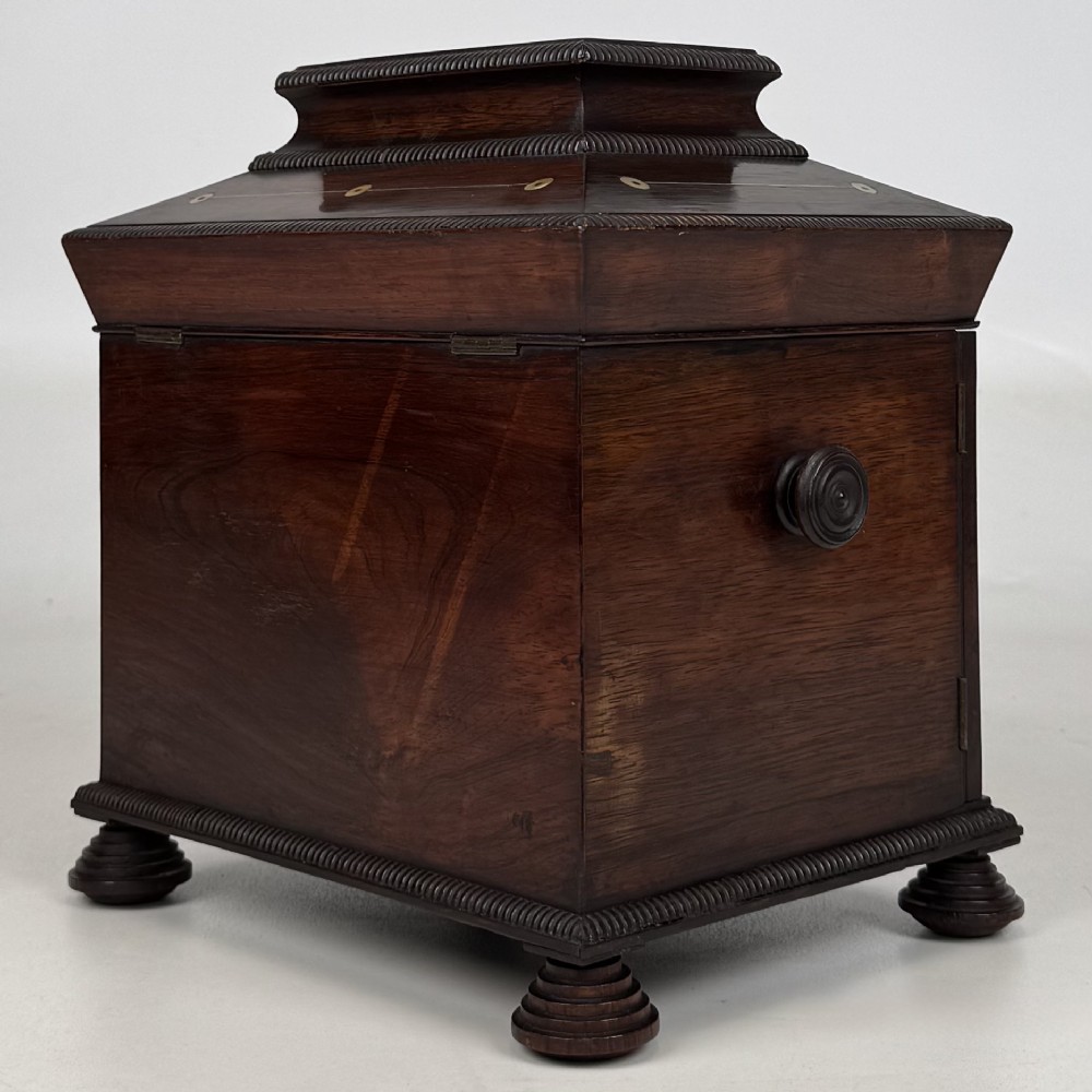 An antique dark rosewood box featuring mother-of-pearl floral inlays, twin front doors, a sarcophagus top, and turned feet. View VII