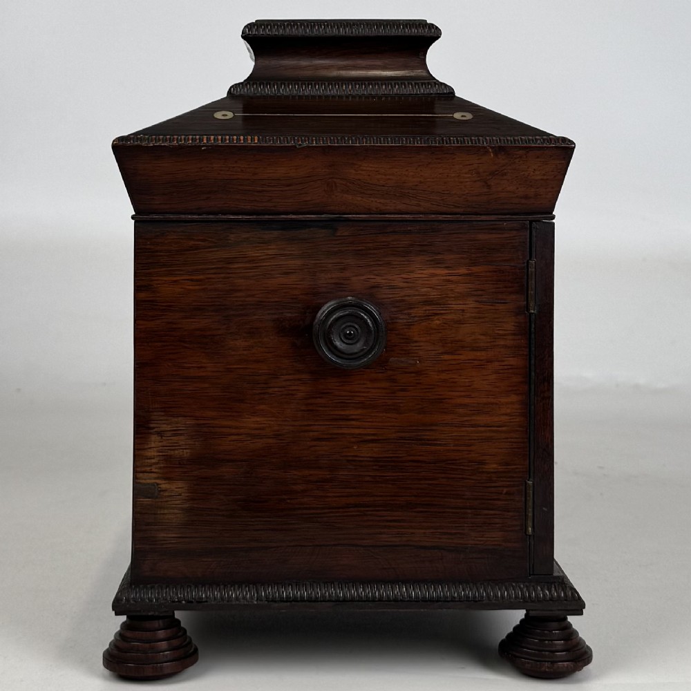 An antique dark rosewood box featuring mother-of-pearl floral inlays, twin front doors, a sarcophagus top, and turned feet. View VIII