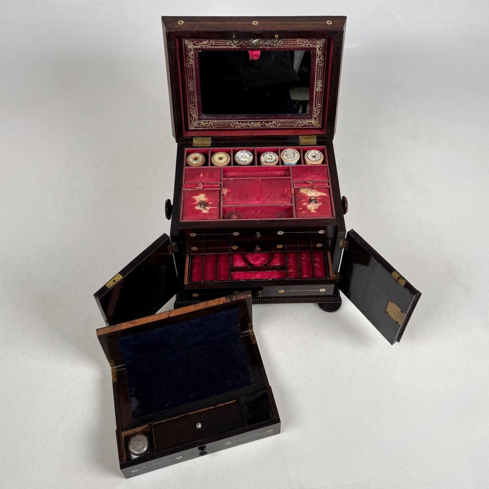 An antique dark rosewood box featuring mother-of-pearl floral inlays, twin front doors, a sarcophagus top, and turned feet. View XII