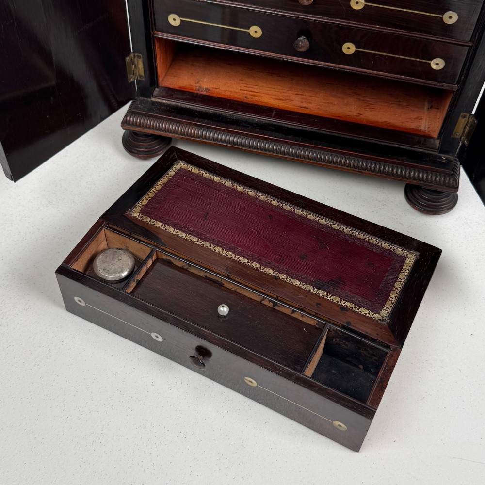 An antique dark rosewood box featuring mother-of-pearl floral inlays, twin front doors, a sarcophagus top, and turned feet. View XIII