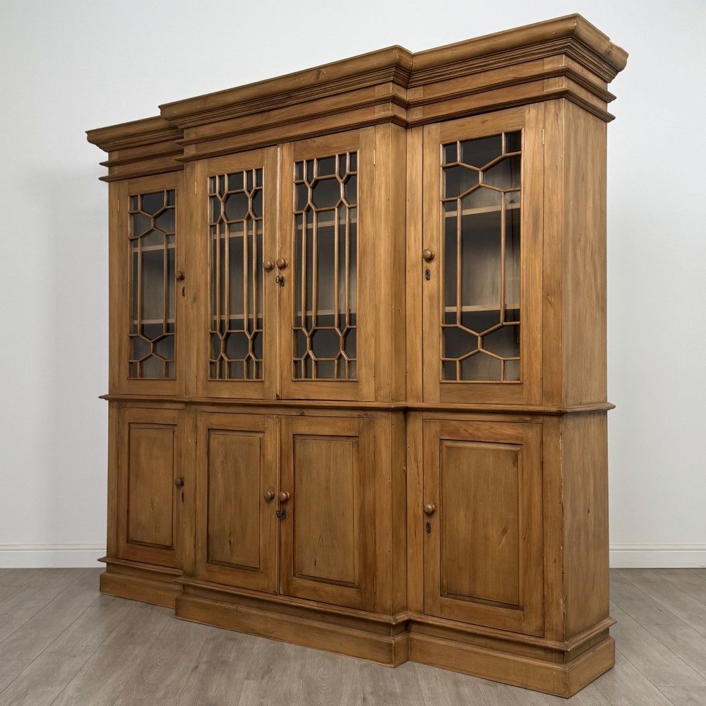 A large 20th-century pine breakfront bookcase featuring upper astragal glazed doors and lower solid panel doors. View III