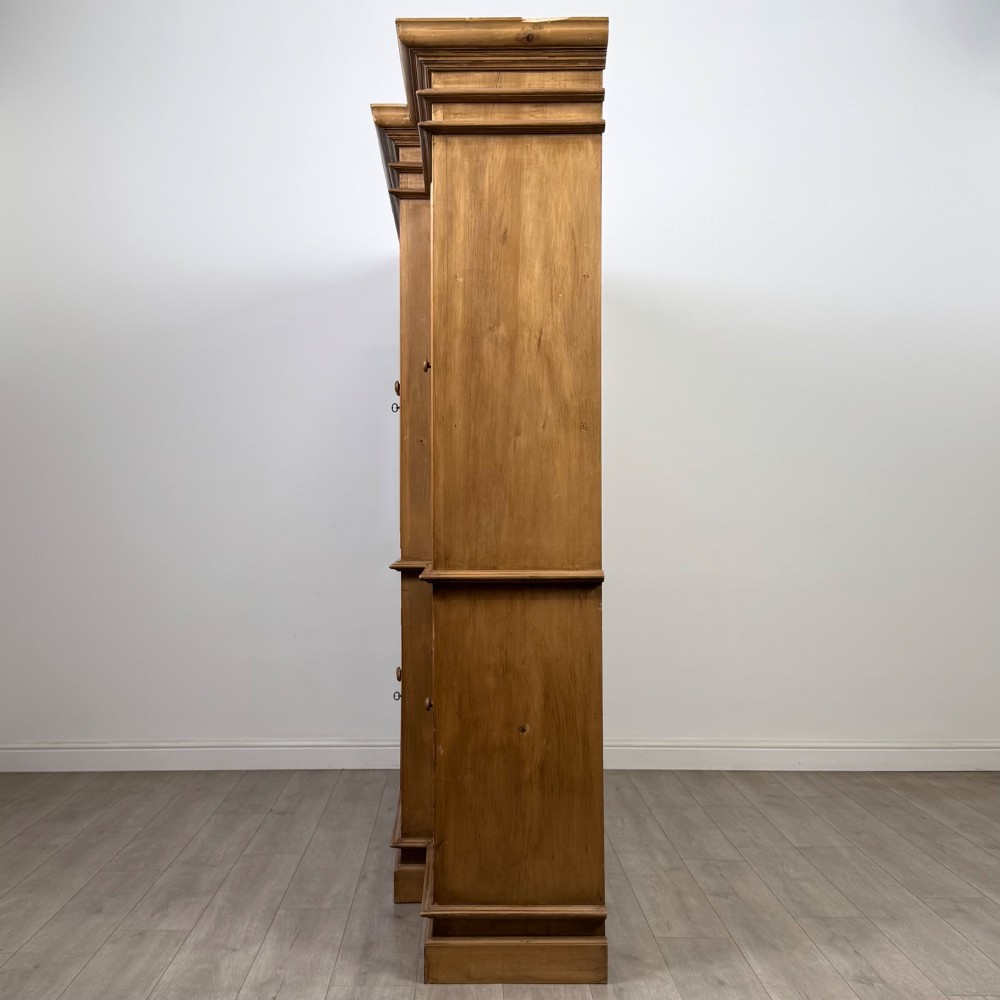 A large 20th-century pine breakfront bookcase featuring upper astragal glazed doors and lower solid panel doors. View IV