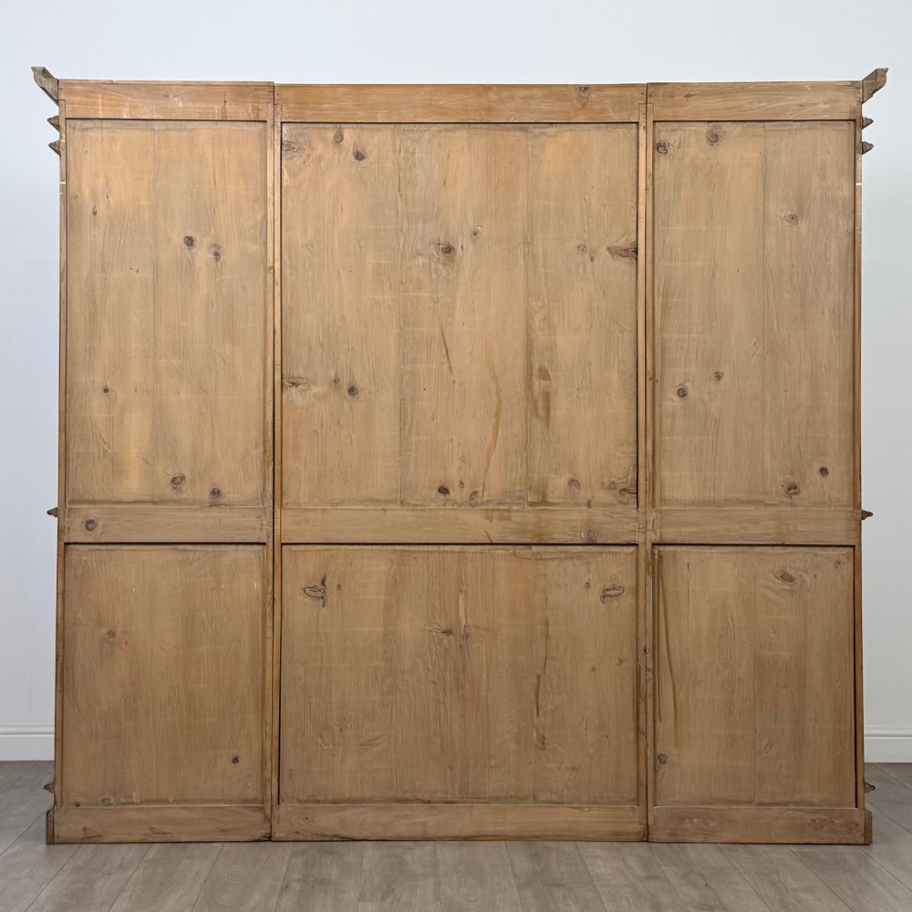 A large 20th-century pine breakfront bookcase featuring upper astragal glazed doors and lower solid panel doors. View VI