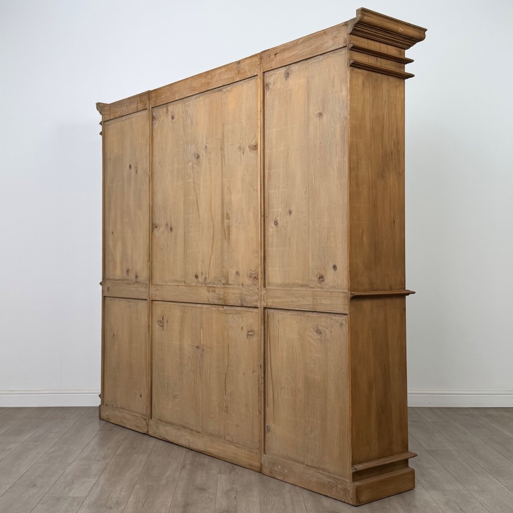 A large 20th-century pine breakfront bookcase featuring upper astragal glazed doors and lower solid panel doors. View VII