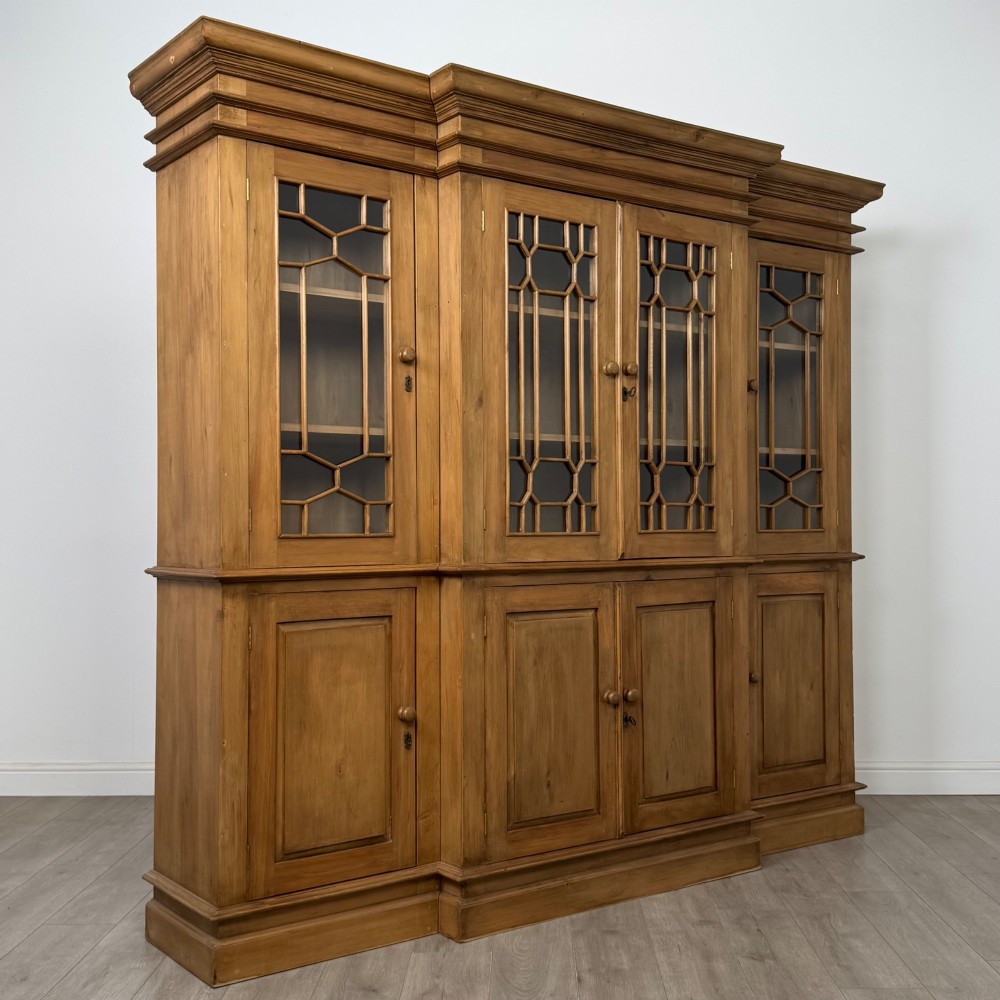 A large 20th-century pine breakfront bookcase featuring upper astragal glazed doors and lower solid panel doors. View IX