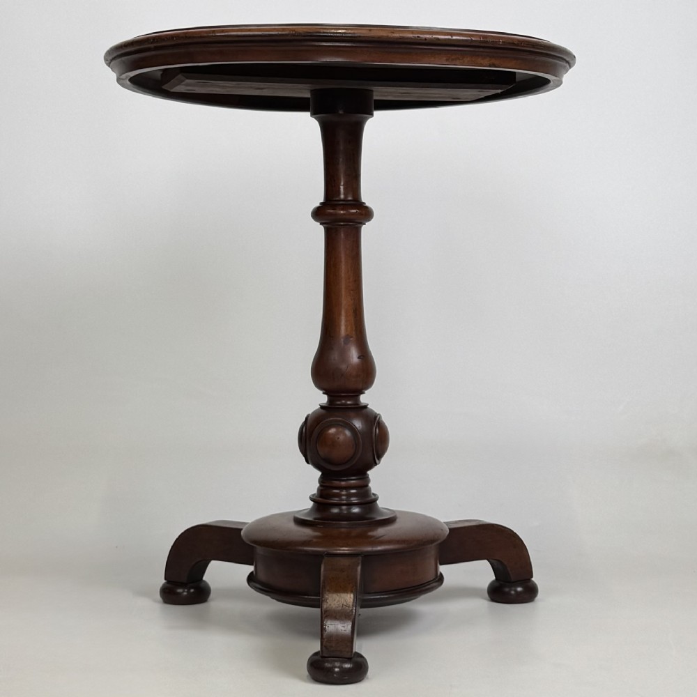 A 19th-century Victorian mahogany side table featuring a moulded circular top set upon a central turned pedestal and a four-footed base.