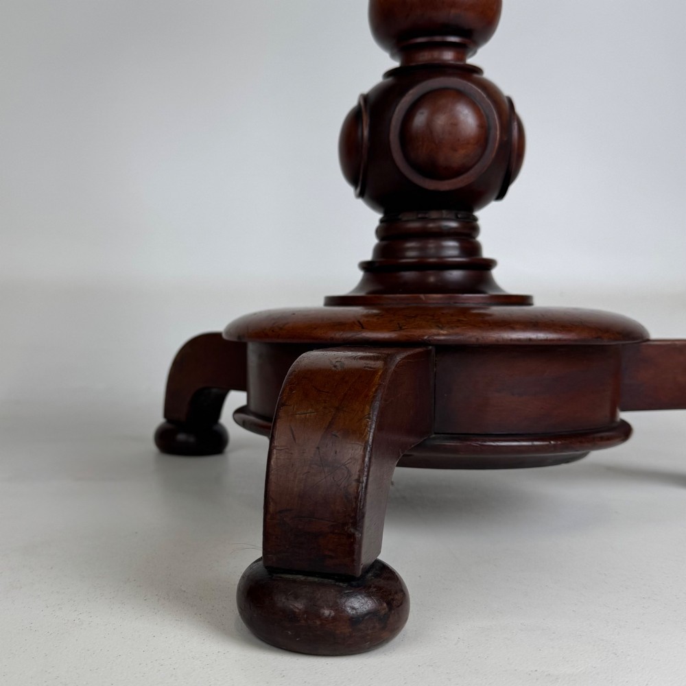 A 19th-century Victorian mahogany side table featuring a moulded circular top set upon a central turned pedestal and a four-footed base. View V