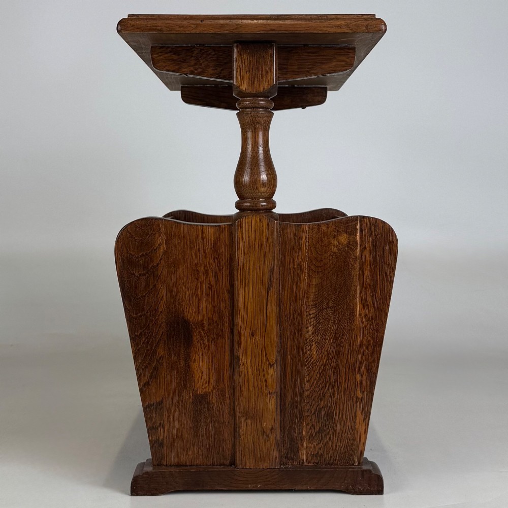 A medium oak side table featuring a flat rectangular tabletop supported by turned baluster posts above a lower slatted storage trough. View III