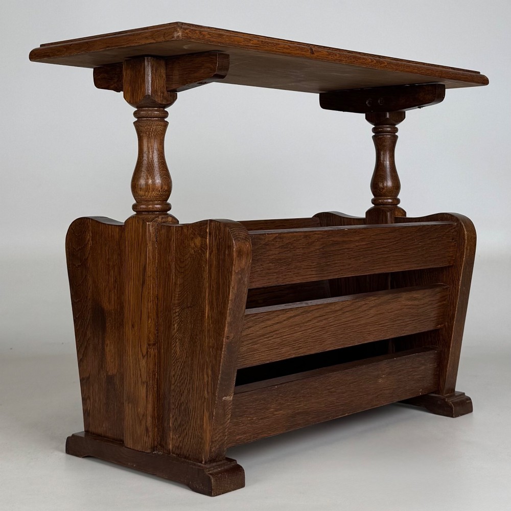 A medium oak side table featuring a flat rectangular tabletop supported by turned baluster posts above a lower slatted storage trough. View IV