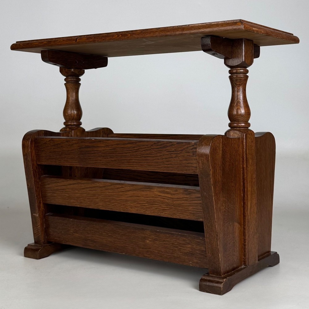 A medium oak side table featuring a flat rectangular tabletop supported by turned baluster posts above a lower slatted storage trough. View VI