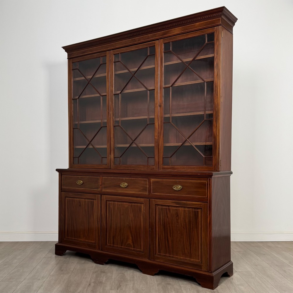 An 18th-century Georgian mahogany bookcase featuring three glazed doors with geometric astragal bars above three drawers and three panelled cupboard doors. View III