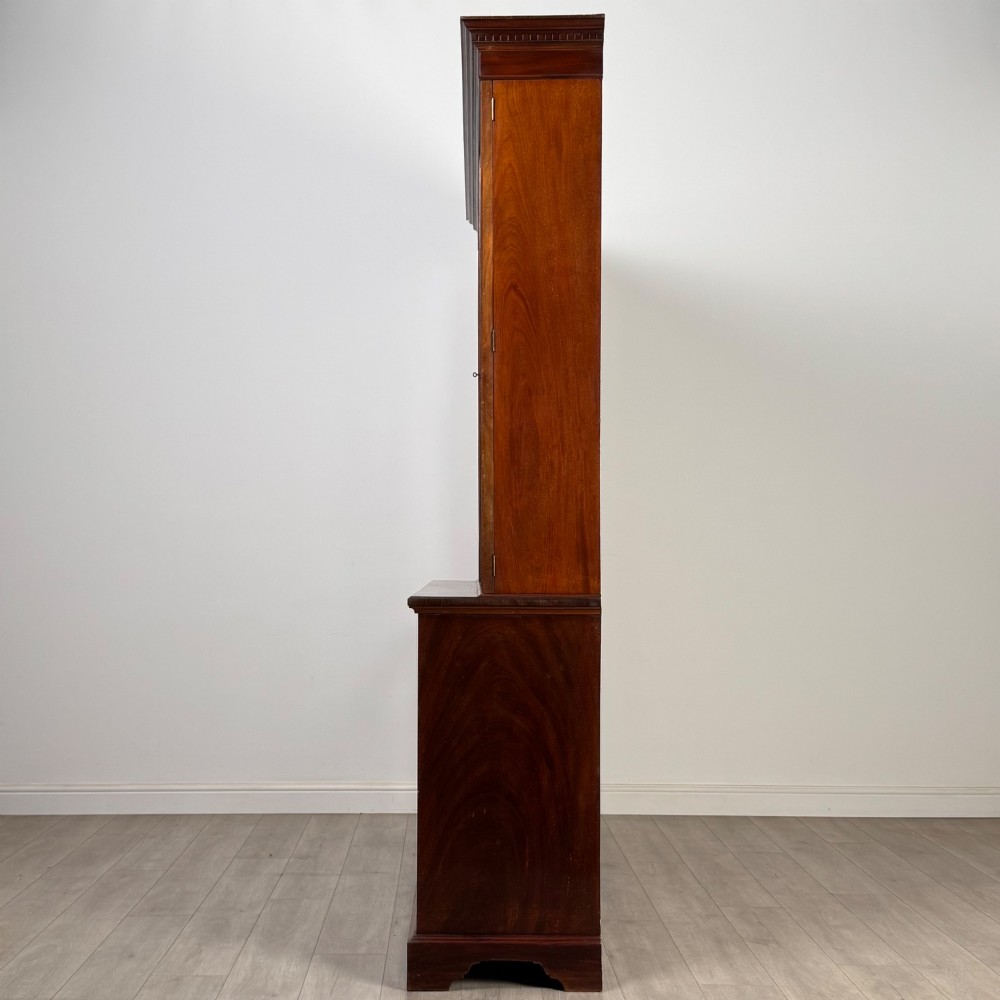An 18th-century Georgian mahogany bookcase featuring three glazed doors with geometric astragal bars above three drawers and three panelled cupboard doors. View IV