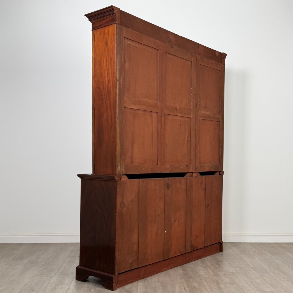 An 18th-century Georgian mahogany bookcase featuring three glazed doors with geometric astragal bars above three drawers and three panelled cupboard doors. View V