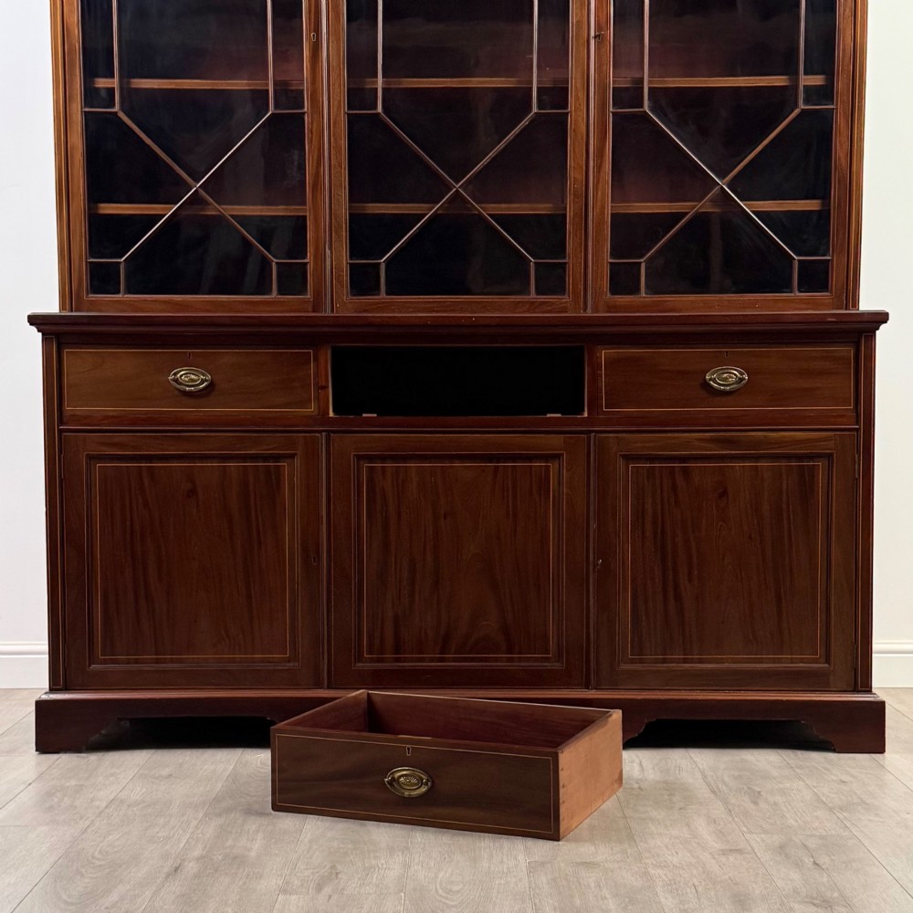 An 18th-century Georgian mahogany bookcase featuring three glazed doors with geometric astragal bars above three drawers and three panelled cupboard doors. View XI