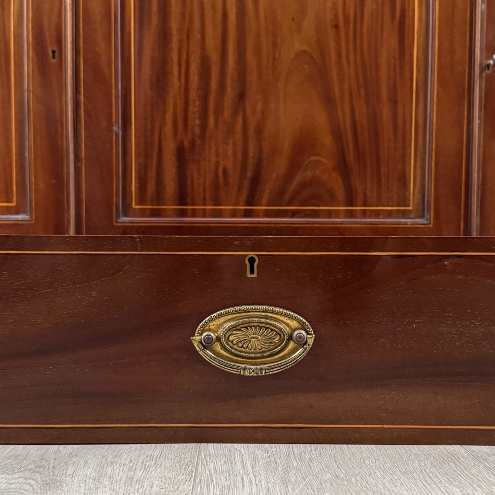 An 18th-century Georgian mahogany bookcase featuring three glazed doors with geometric astragal bars above three drawers and three panelled cupboard doors. View XII