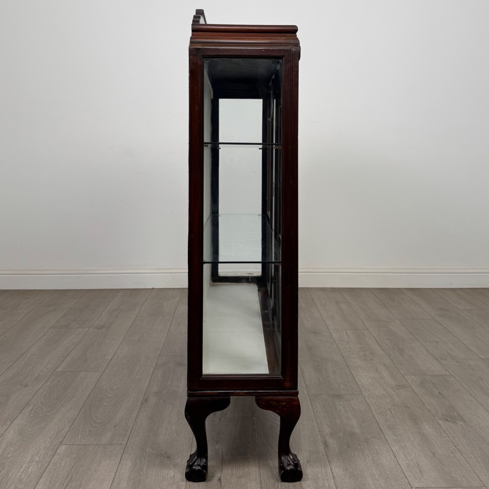 An Edwardian mahogany display cabinet featuring twin astragal glazed doors, glass interior shelves, and cabriole legs with ball and claw feet. View VIII
