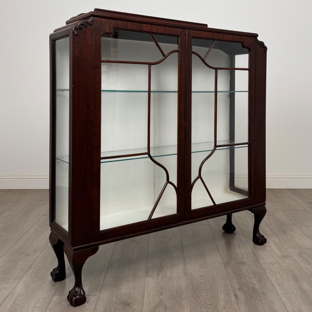 An Edwardian mahogany display cabinet featuring twin astragal glazed doors, glass interior shelves, and cabriole legs with ball and claw feet. View IX