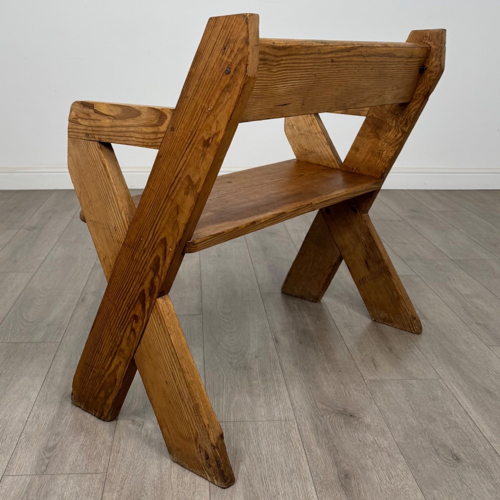 A nineteenth-century pitch pine bench featuring an X-frame structure, integrated side armrests, and a single horizontal back rail. View III
