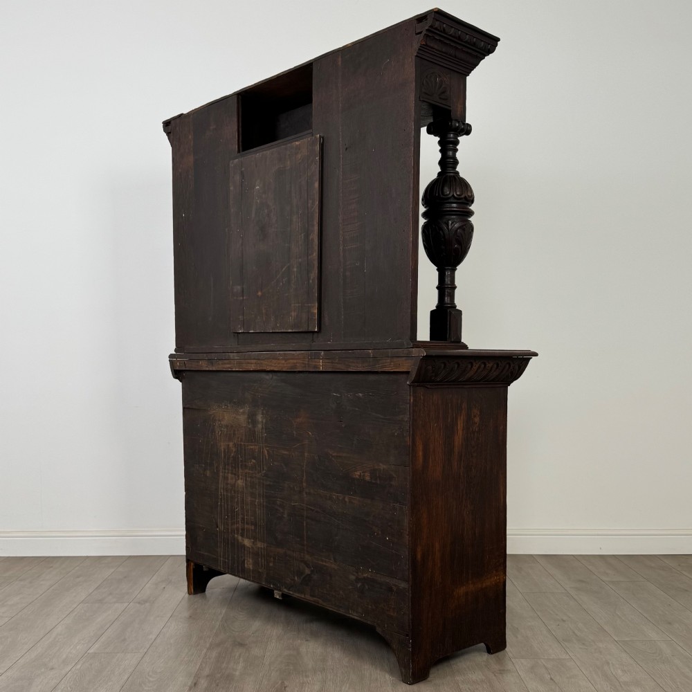 A 19th-century dark carved oak Victorian sideboard featuring an upper mirrored shelf section supported by turned bulbous pilasters above two carved drawers and cupboard doors with rosette reliefs. View VII