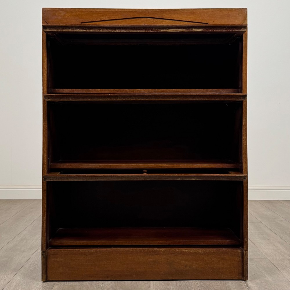A three-tier mahogany sectional bookcase featuring lift-up glazed doors with small wooden knobs. View II