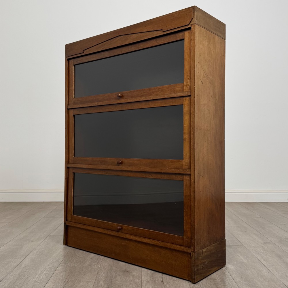A three-tier mahogany sectional bookcase featuring lift-up glazed doors with small wooden knobs. View III