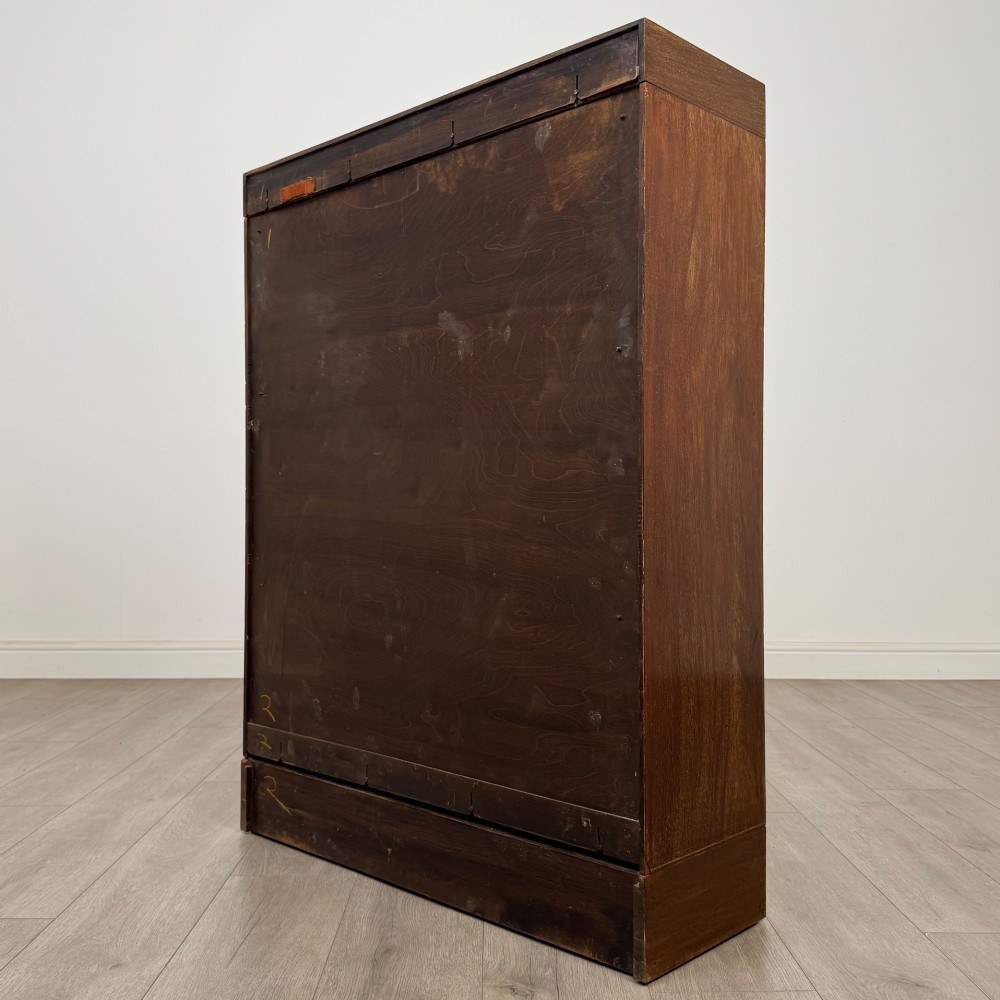 A three-tier mahogany sectional bookcase featuring lift-up glazed doors with small wooden knobs. View VII