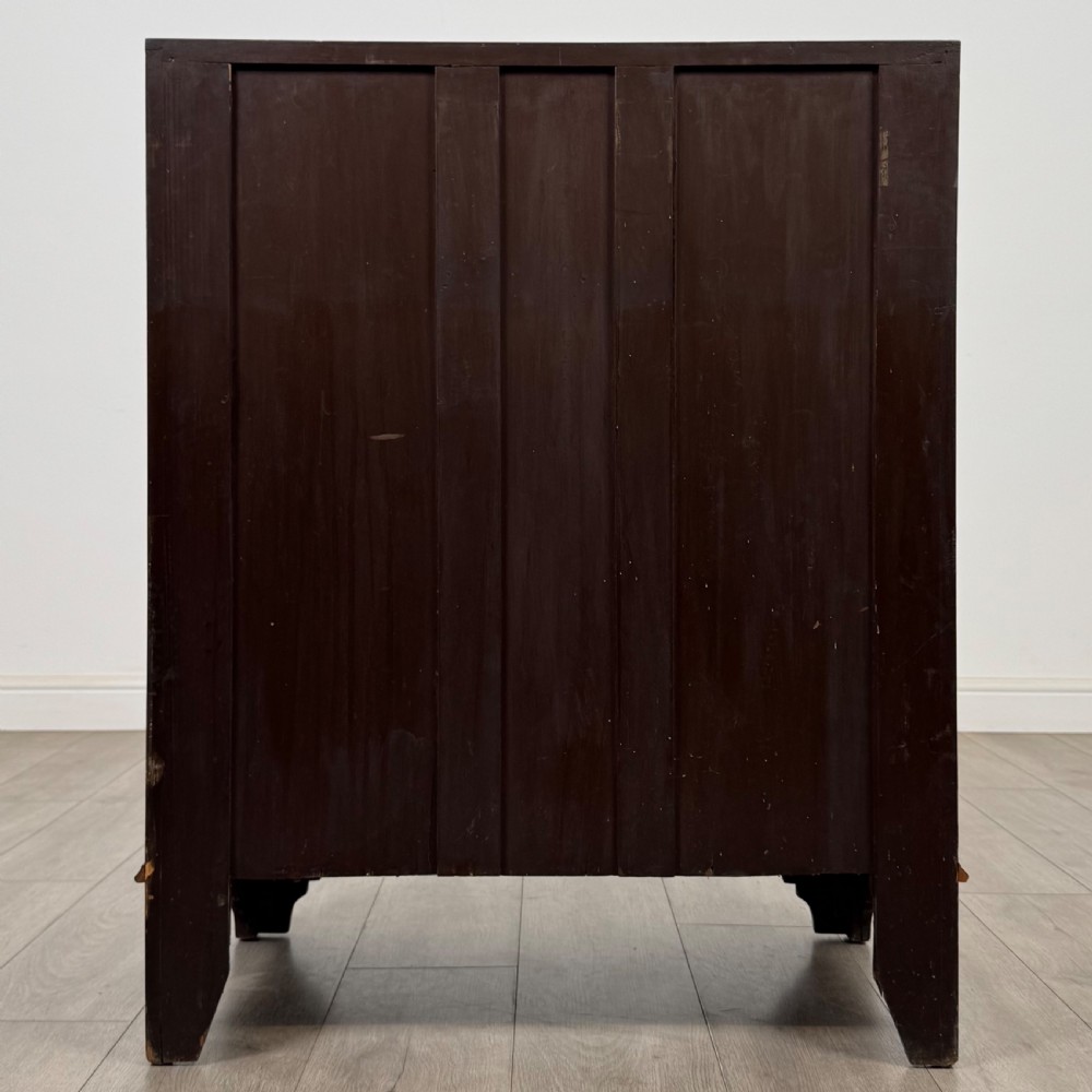 An Edwardian mahogany writing bureau featuring a slant front top, three long drawers with brass drop handles, and shaped bracket feet. View VI