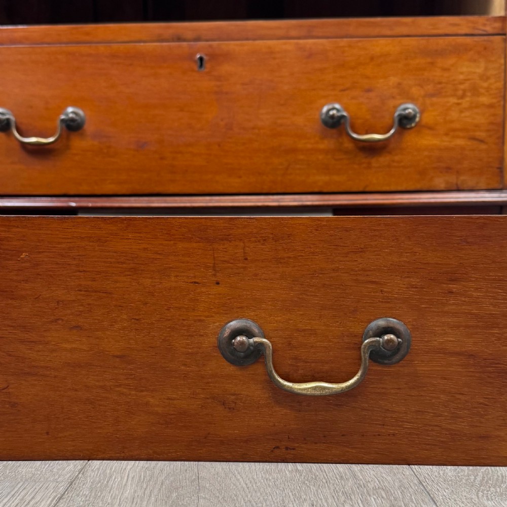 An Edwardian mahogany writing bureau featuring a slant front top, three long drawers with brass drop handles, and shaped bracket feet. View XIII
