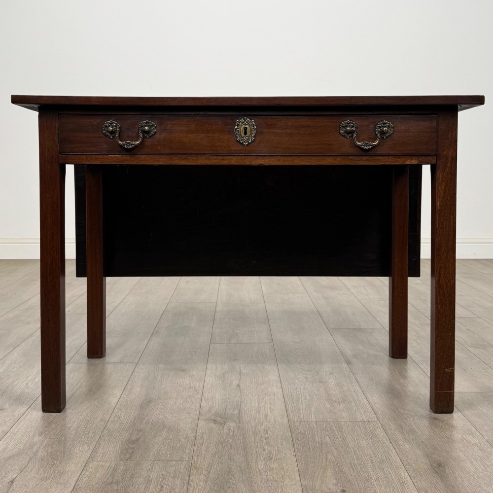 An 18th-century Georgian mahogany writing table featuring a rectangular top, a single wide frieze drawer with brass handles and central escutcheon, supported by straight square legs.