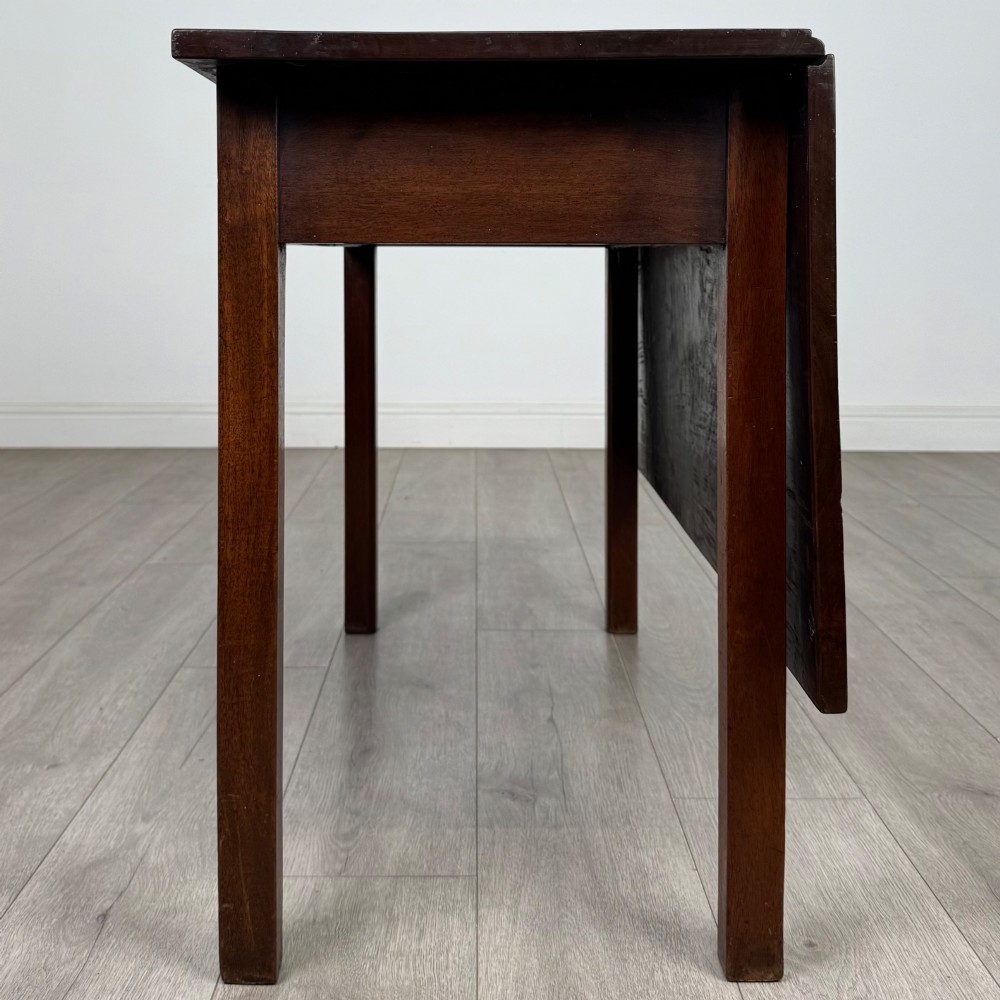 An 18th-century Georgian mahogany writing table featuring a rectangular top, a single wide frieze drawer with brass handles and central escutcheon, supported by straight square legs. View III