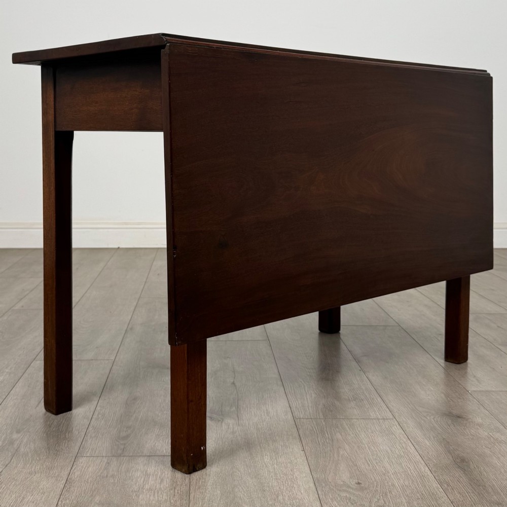 An 18th-century Georgian mahogany writing table featuring a rectangular top, a single wide frieze drawer with brass handles and central escutcheon, supported by straight square legs. View V