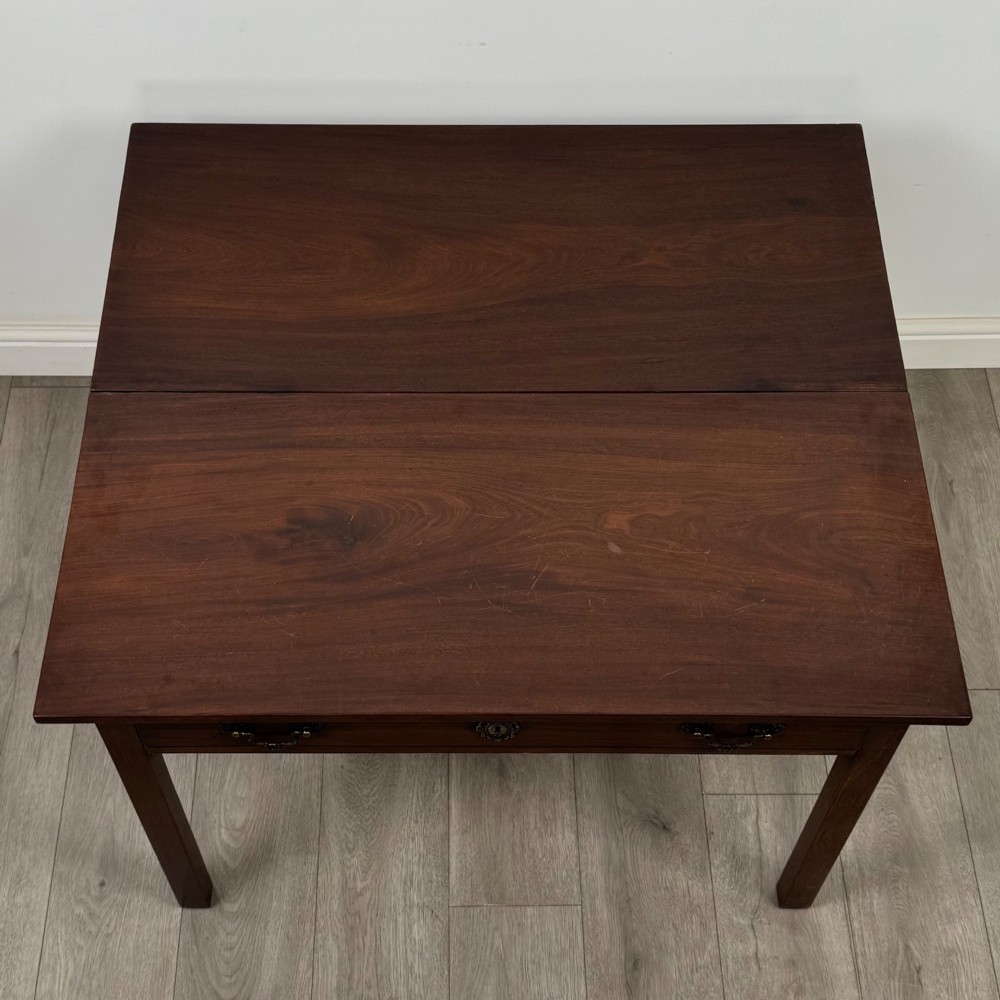 An 18th-century Georgian mahogany writing table featuring a rectangular top, a single wide frieze drawer with brass handles and central escutcheon, supported by straight square legs. View XI